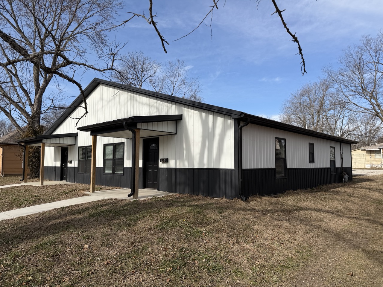 Side exterior view of a custom barndominium with metal siding and covered entry built by Building Pros LLC in Kansas