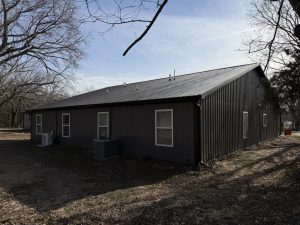 Wide side view of a metal-sided stud-frame duplex with residential windows built by Building Pros LLC in Garnett, Kansas